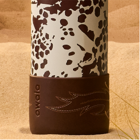 Cow print Owala bottle in sand